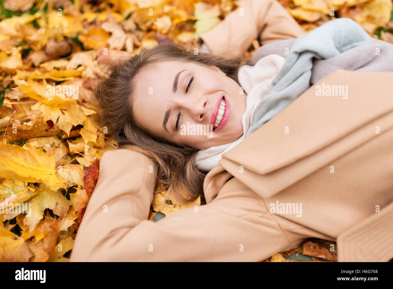 beautiful happy woman lying on autumn leaves Stock Photo - Alamy