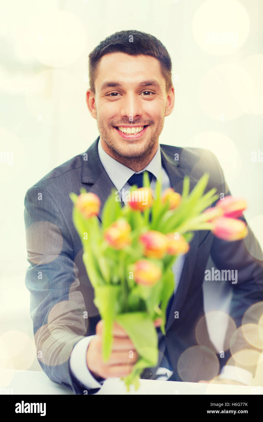smiling handsome man giving bouquet of flowers Stock Photo Alamy