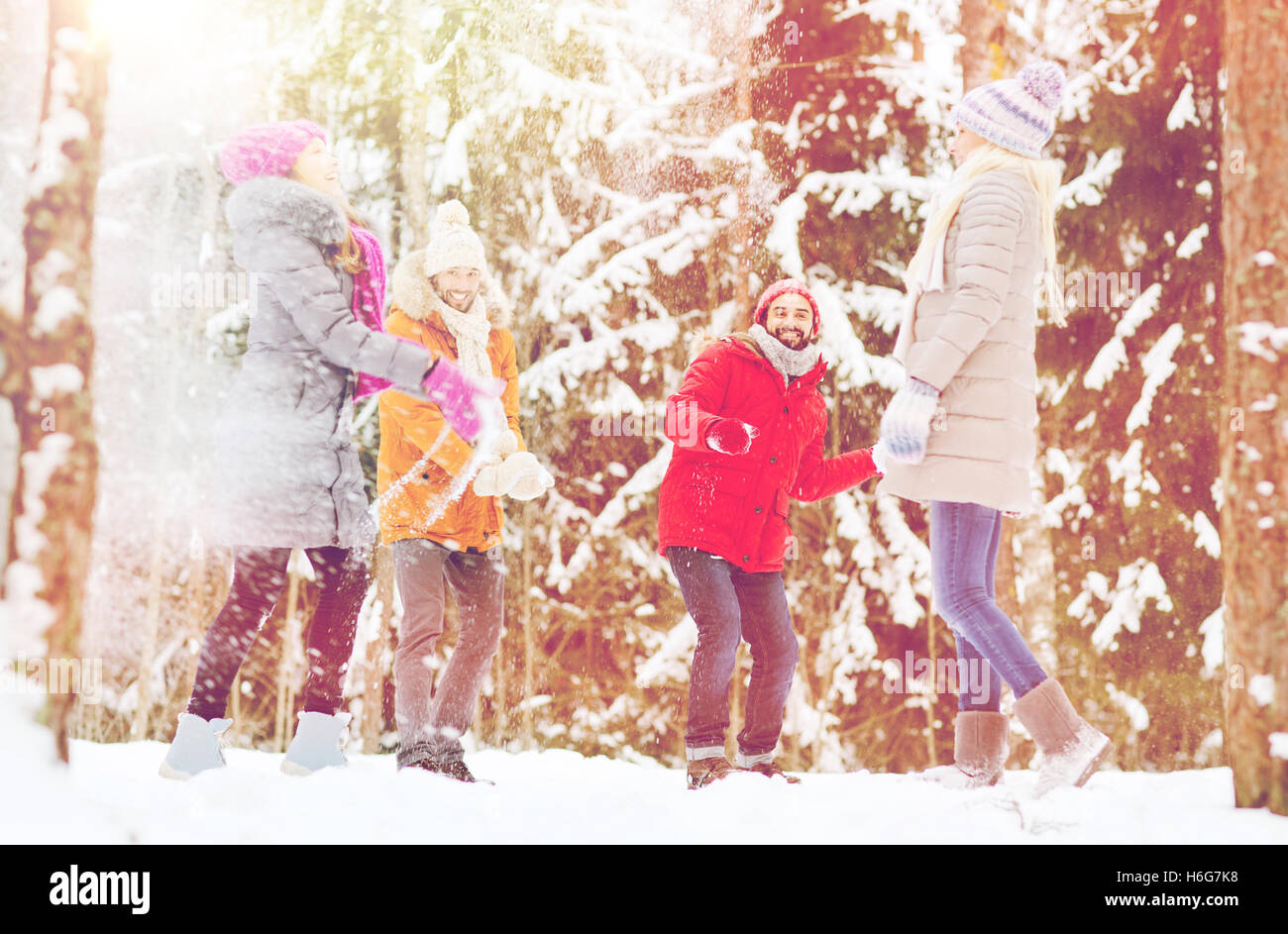 group of happy friends playing snowballs in forest Stock Photo - Alamy