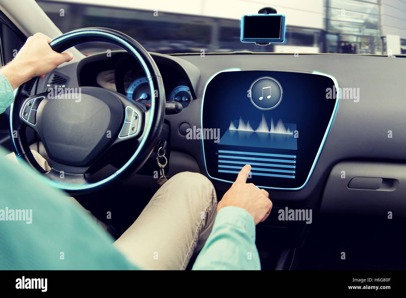 close up of man driving car with audio system Stock Photo