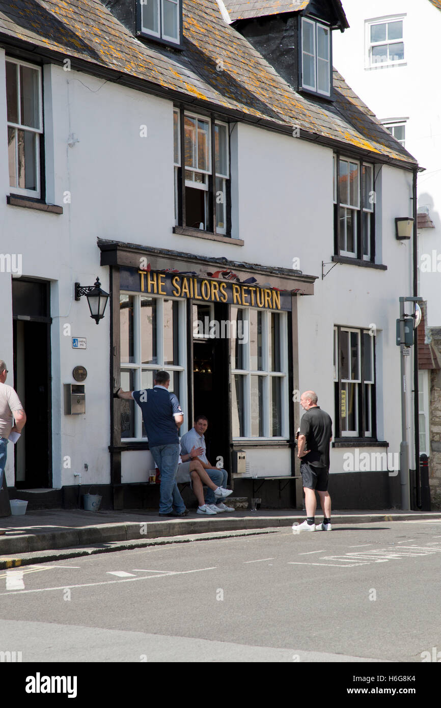 Men enjoying a lunchtime drink outside a pub in Weymouth harbour, Dorset Stock Photo