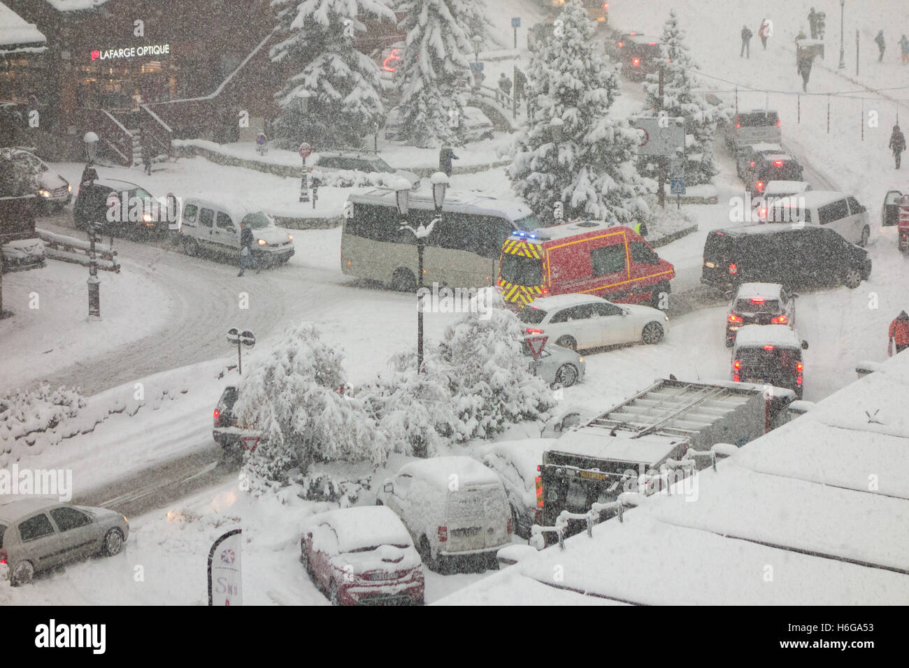 VSAV fire department ambulance making its way through gridlocked roads in Courchevel 1850 during snow fall Stock Photo