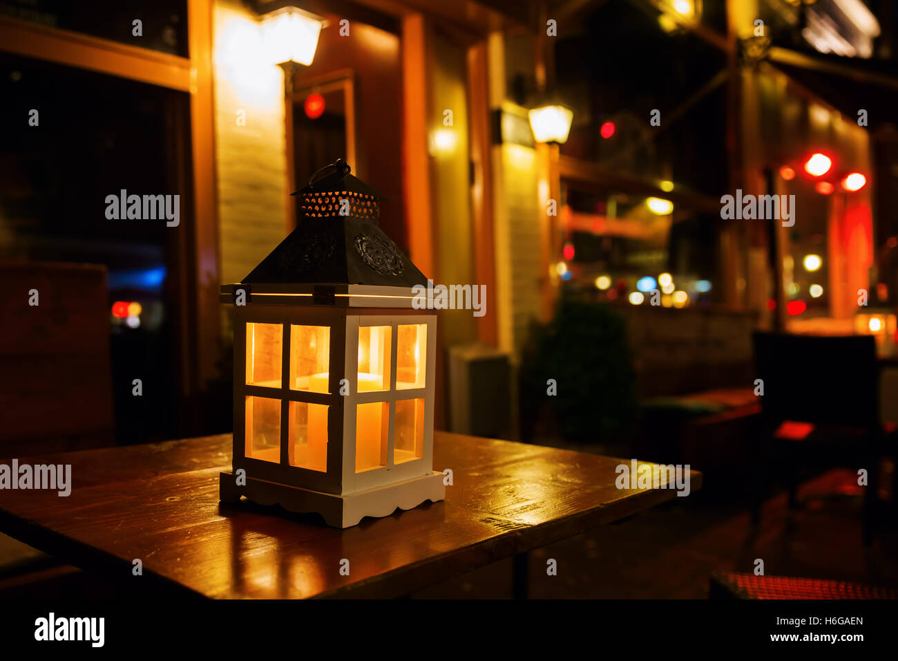 picturesque scene of a lantern on a table at night Stock Photo