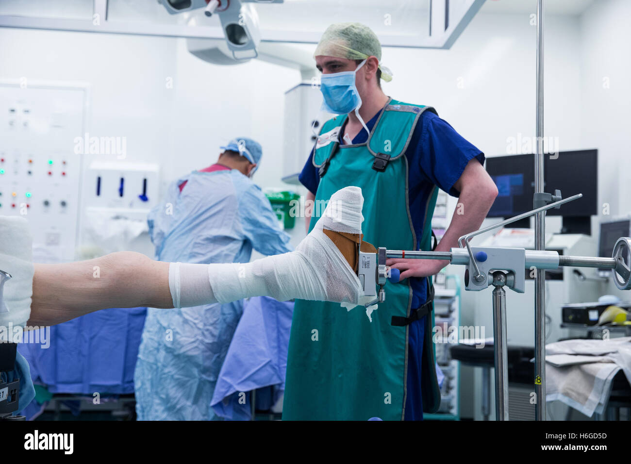 A surgeon and staff prepare a patient for surgery prior to performing an open reduction and internal fixation of a left ankle Stock Photo