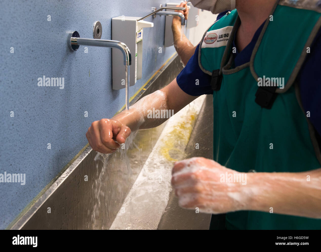 Hospital Surgeon and technician washing hands and arms prior to an operation in the hospital theatre Stock Photo