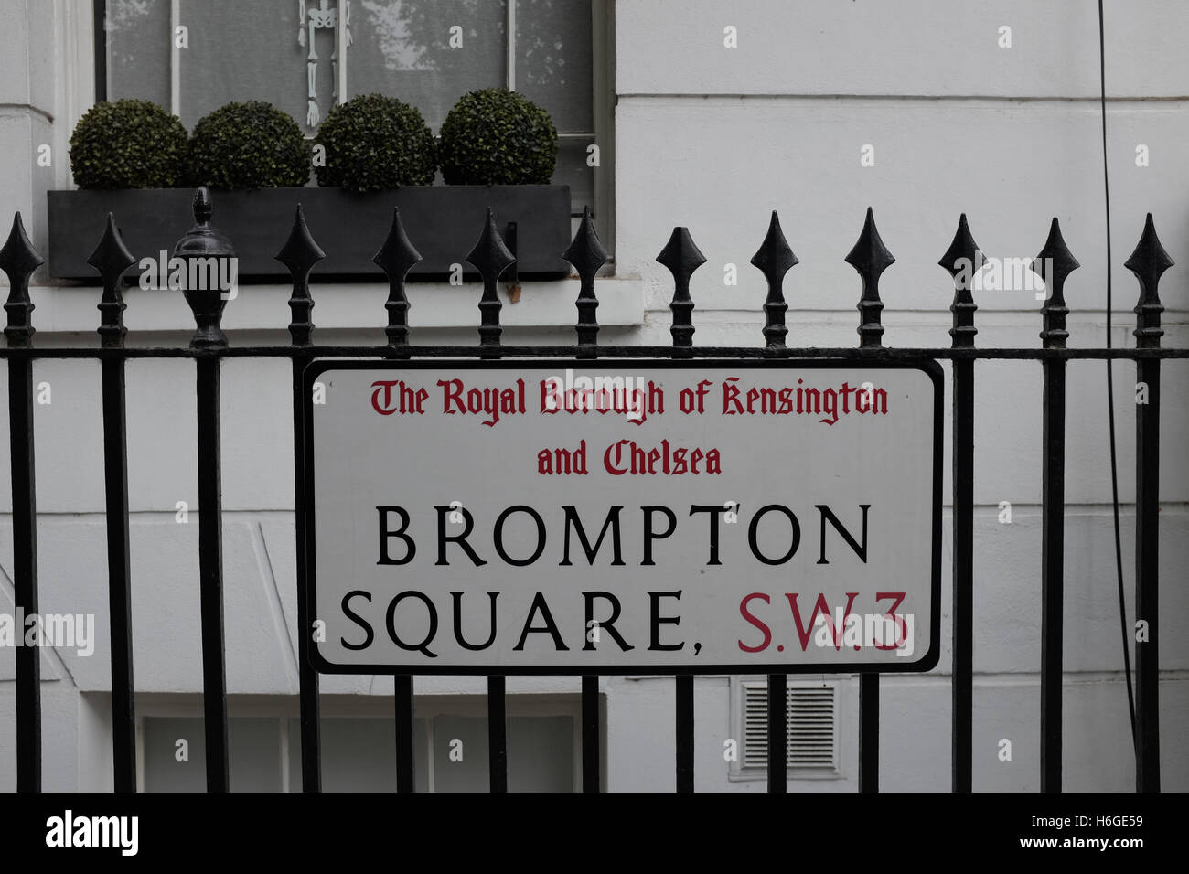 Sign to Brompton Square, London, SW3 on iron railings in the Royal ...