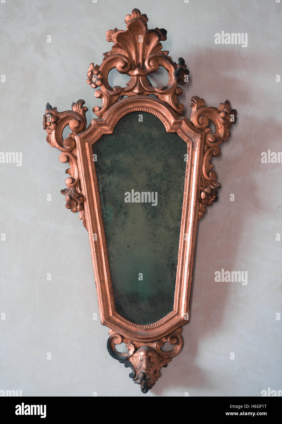 Classic antique mirror with copper colored frame engraved. Stock Photo