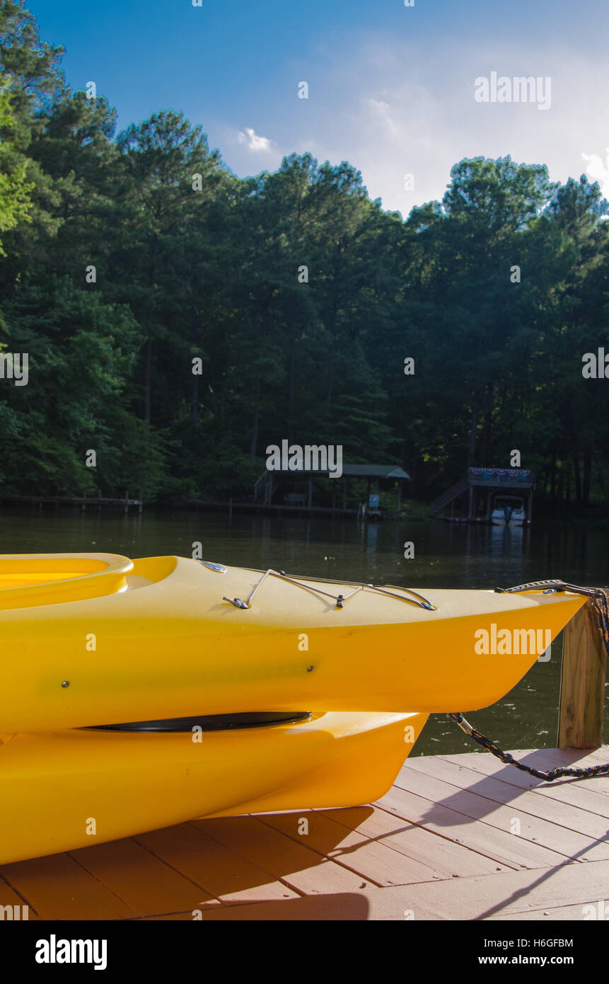 Yellow Kayaks sitting on dock on river Stock Photo