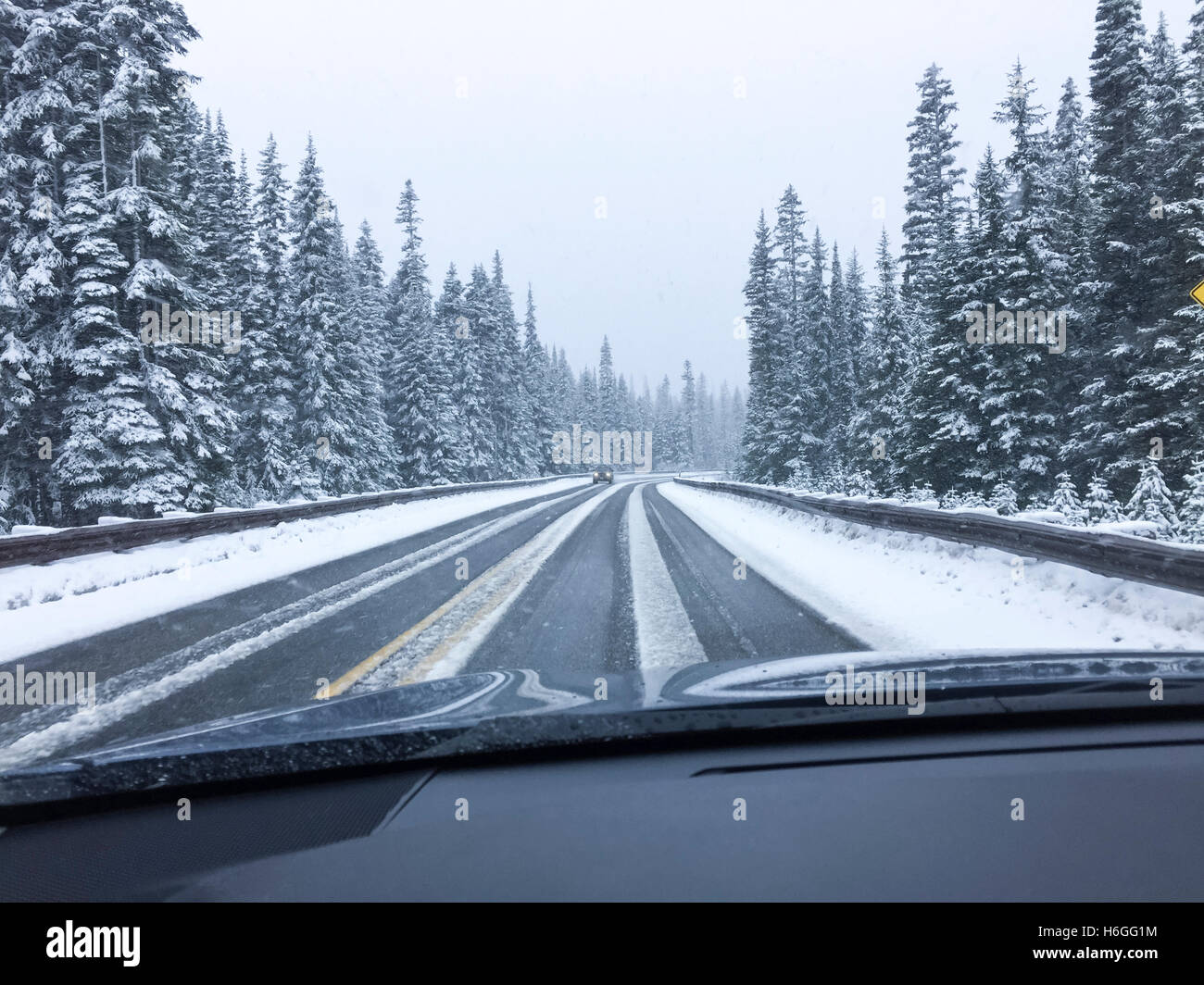 Driver's point of view viewpoint looking through car windshield of snowy road in winter driving Stock Photo