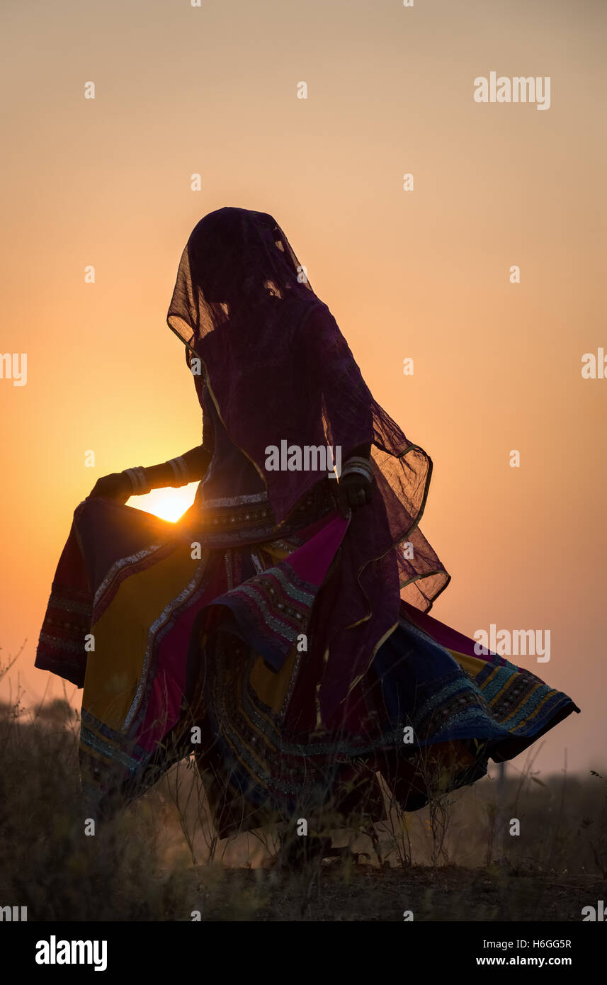 Sunset, silhouette of a woman dancing a traditional dance, Pushkar, Rajasthan, India Stock Photo