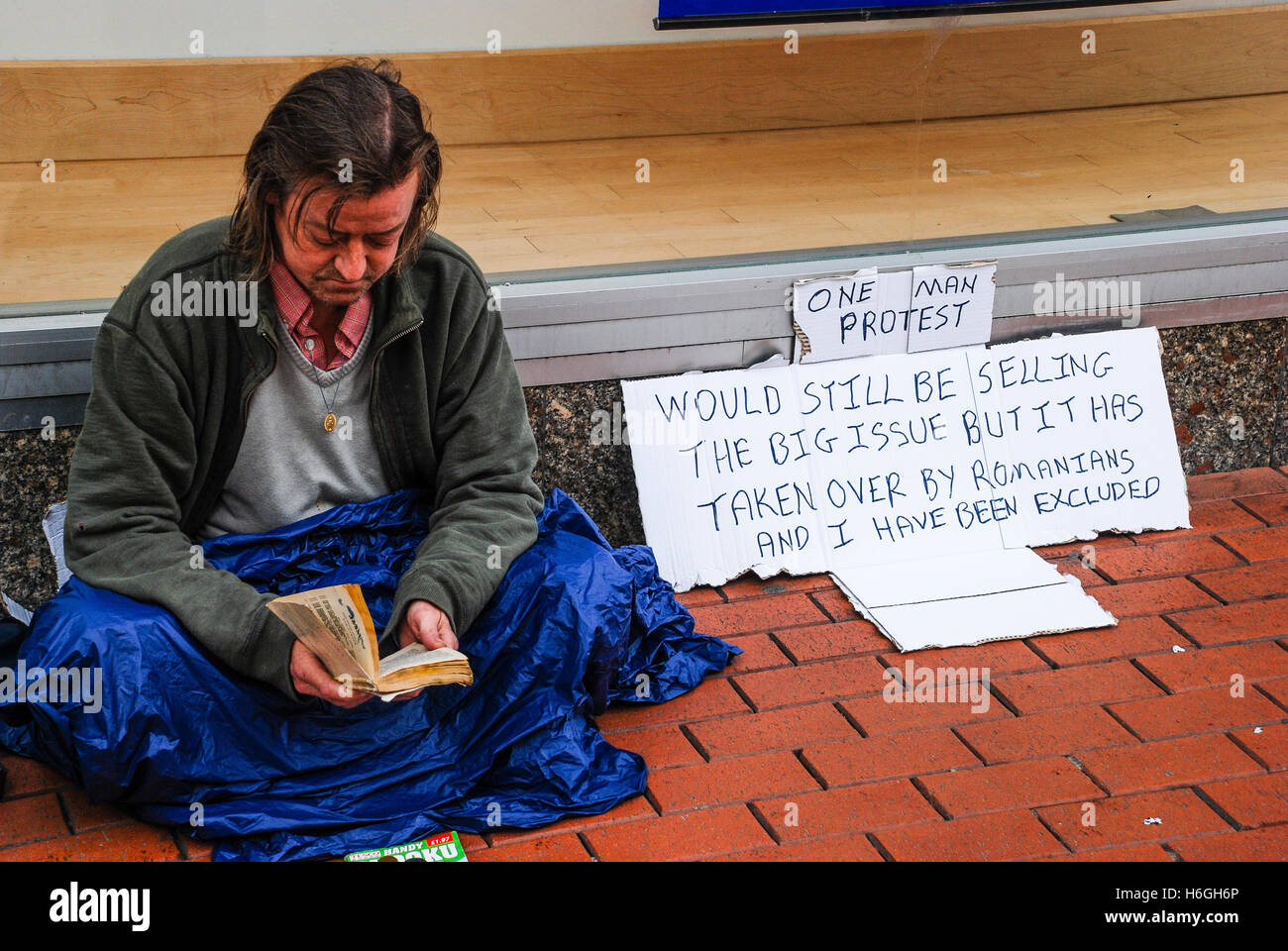 Homeless man protesting against Romainian immigrants who have taken his job selling the Big Issue. Stock Photo
