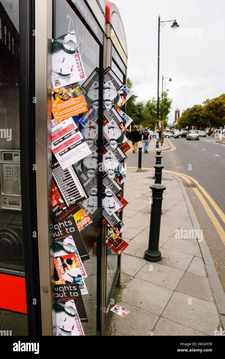 Nightclub invitations and advertising sticking out from doors in BT Telephone Boxes in the student area of Belfast. Stock Photo