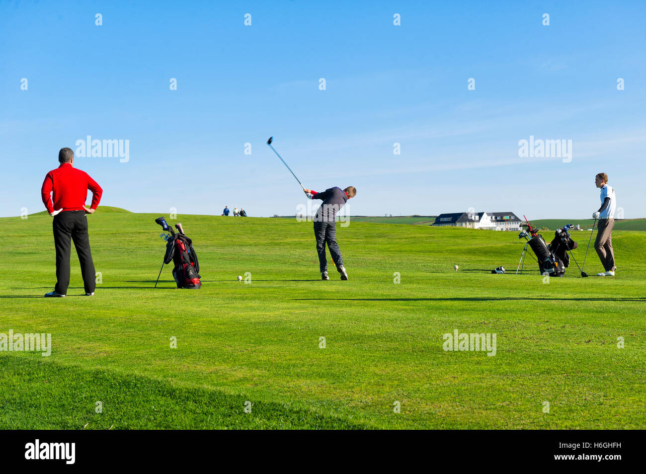 Golfers playing at Thurlestone Golf Club, Devon on a summer's day against a clear blue sky Stock Photo