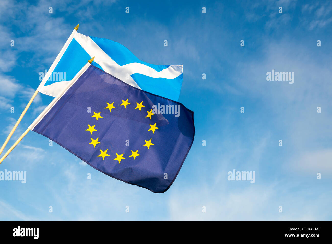 Scottish and EU flags flying in bright blue sky Stock Photo