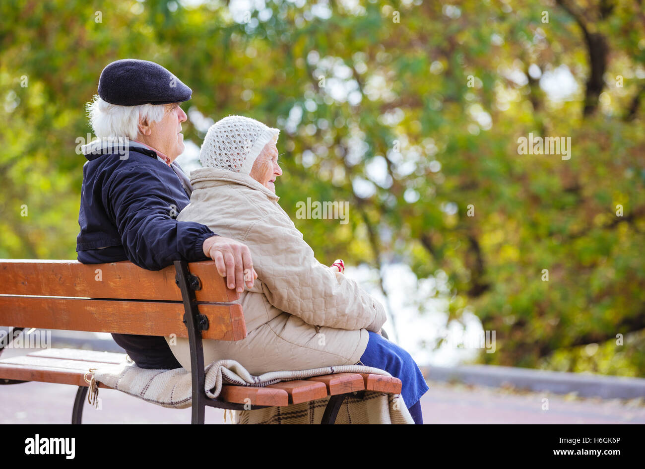 Senior couple sitting on bench in autumn park Stock Photo - Alamy