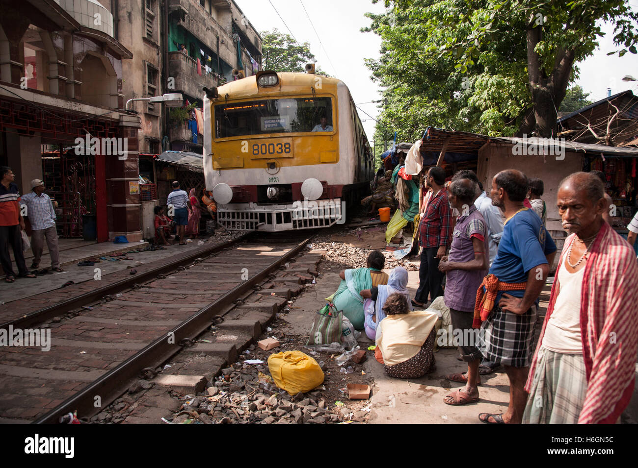 slum  people on near the railway tracks and  local train is passing  Ahiritola  Kolkata West  Bengal India. Stock Photo
