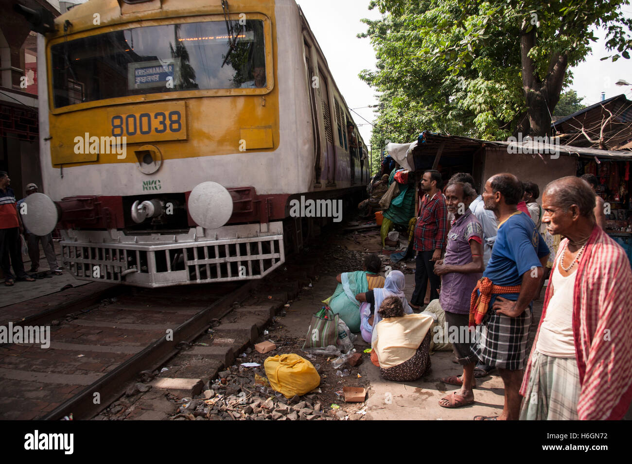 slum  people on near the railway tracks and  local train is passing  Ahiritola  Kolkata West  Bengal India. Stock Photo