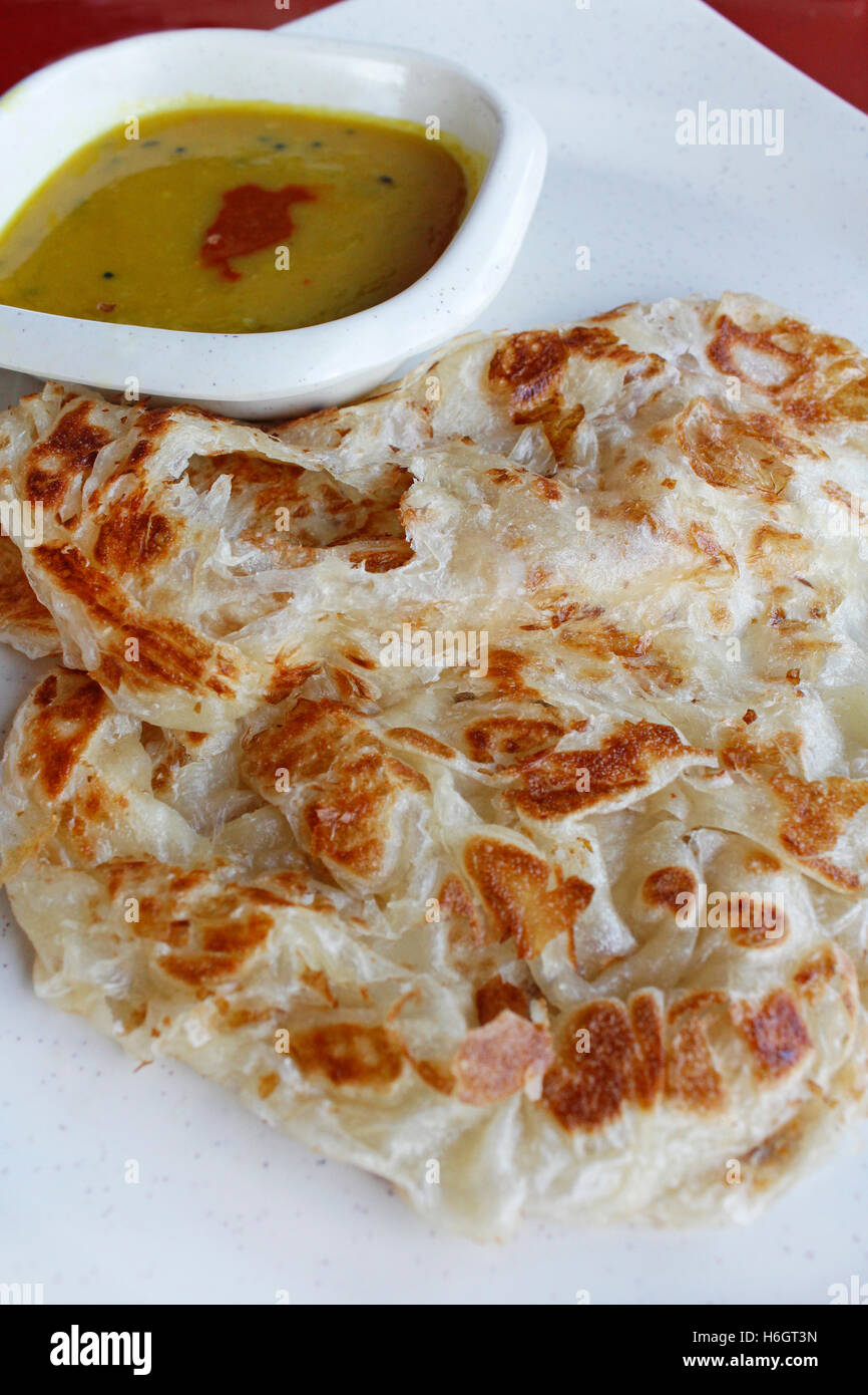 Plain roti canai or pan fried flatbread consisting of dough, egg, ghee and serve with the curry sauce Stock Photo