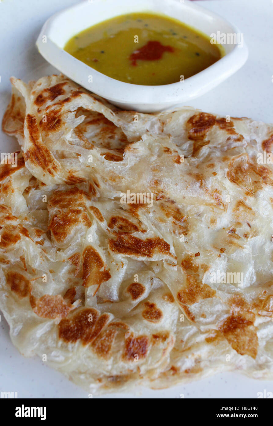 Plain roti canai or pan fried flatbread consisting of dough, egg, ghee and serve with the curry sauce Stock Photo