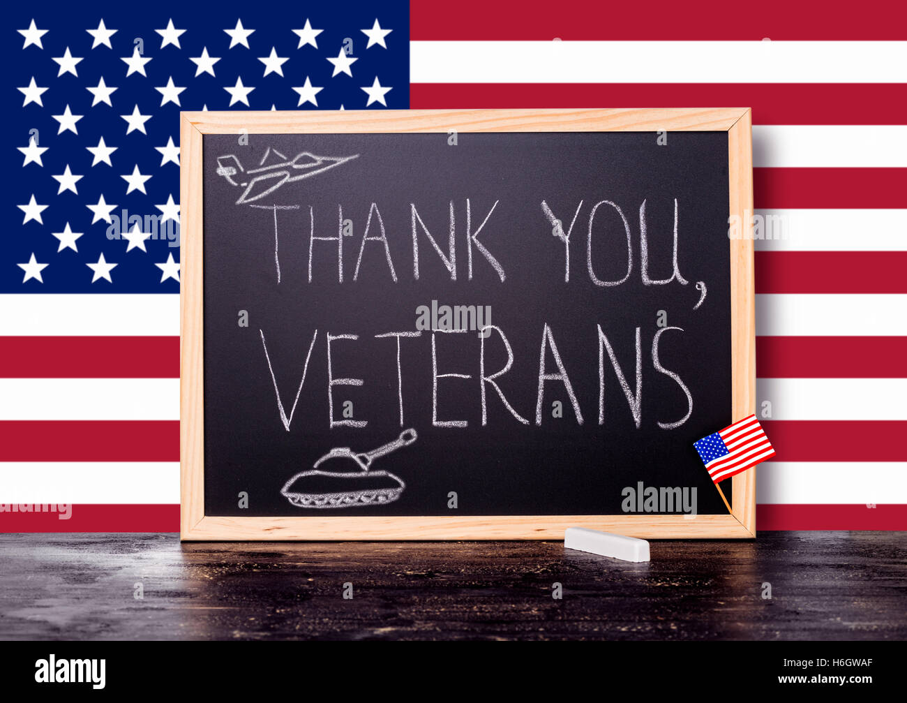 greeting card with handwriting text thank you veterans and  painted tank, plane in chalkboard on flag United States and piece of Stock Photo