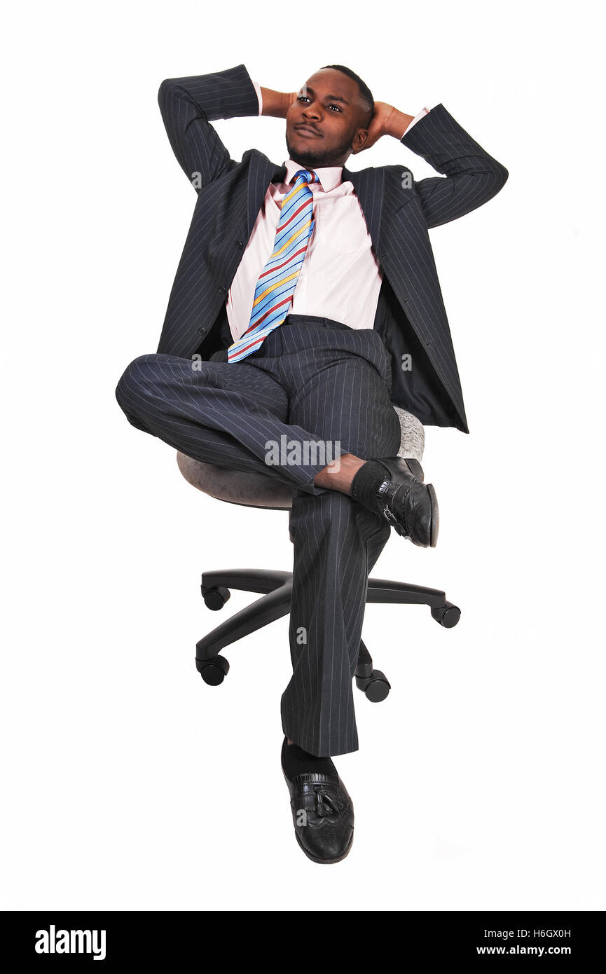 A handsome black man sitting on a chair, his legs crossed and leaning back  and relaxing for white background Stock Photo - Alamy