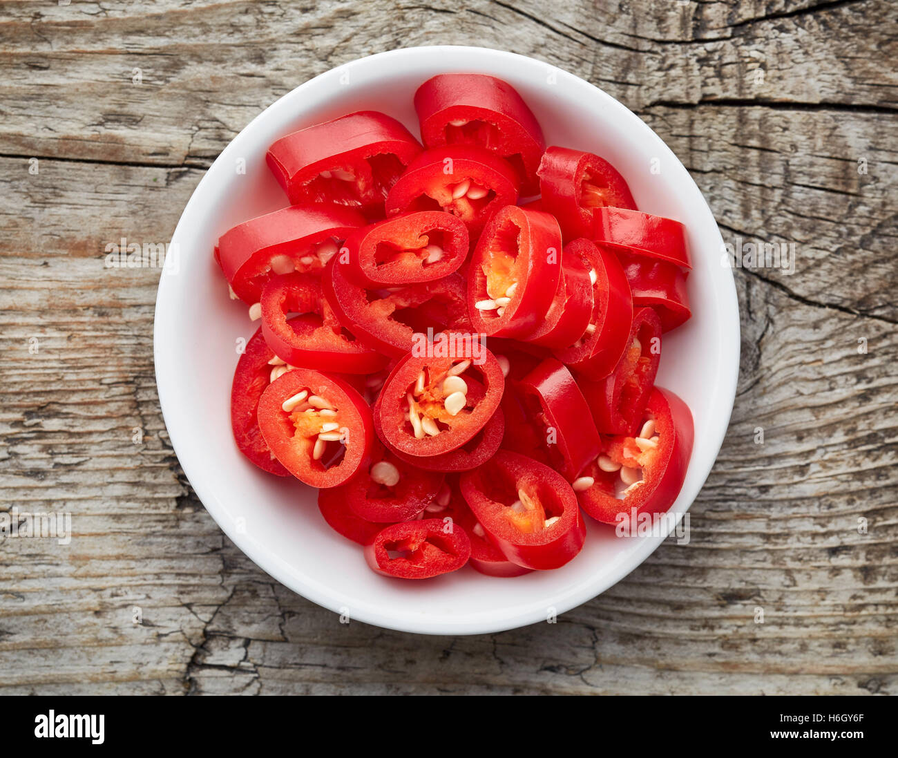 Bowl of red hot chili pepper on wooden table, top view Stock Photo