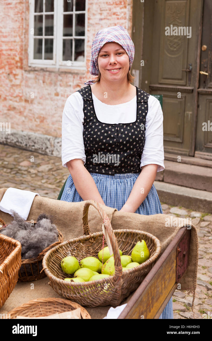 Lady dressed in traditional costume selling fruit, Den Gamle By, Aarhus, Denmark Stock Photo