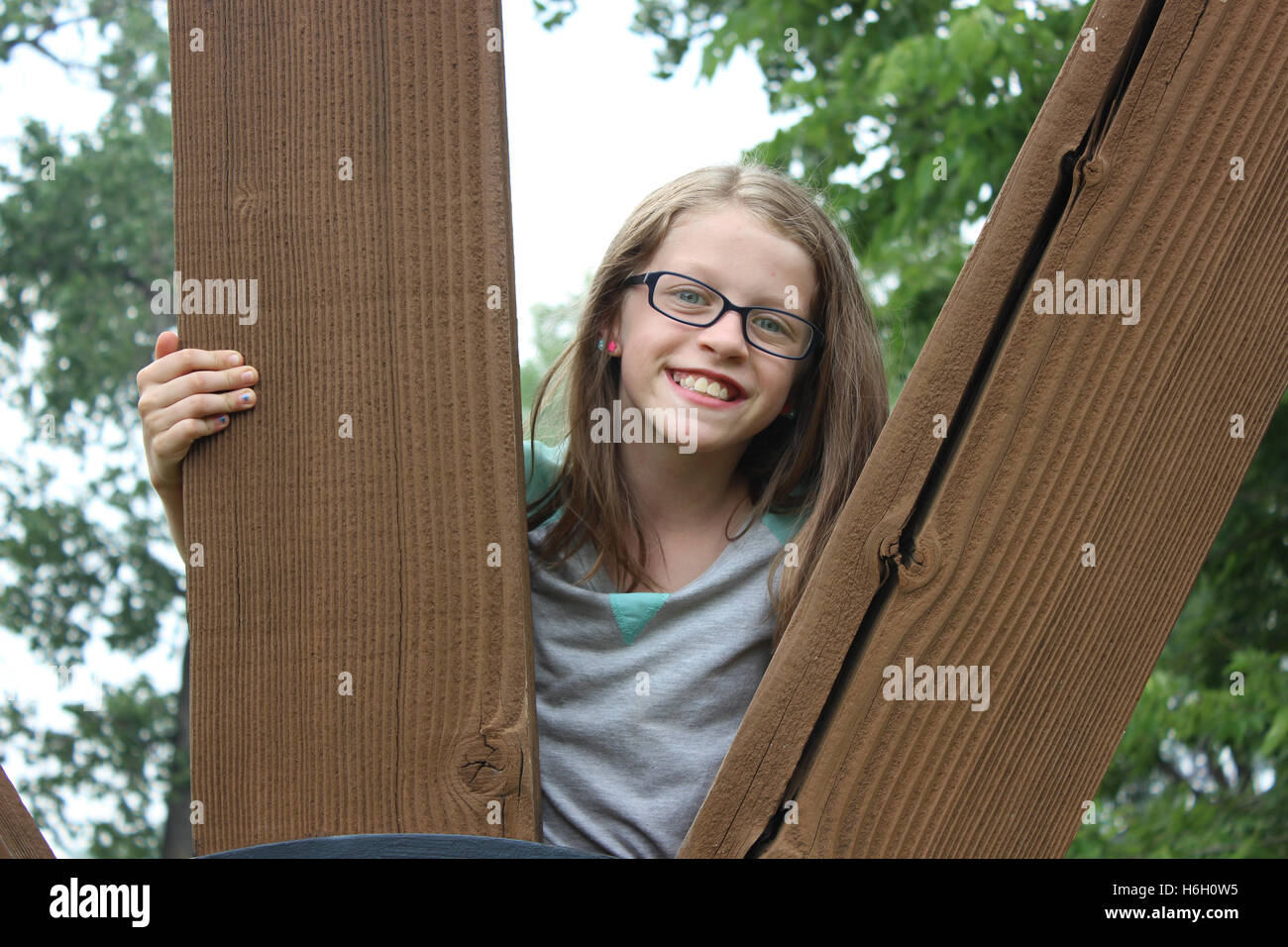 Young Blonde Haired Blue Eyed Girl Peeking Between Two Wooden
