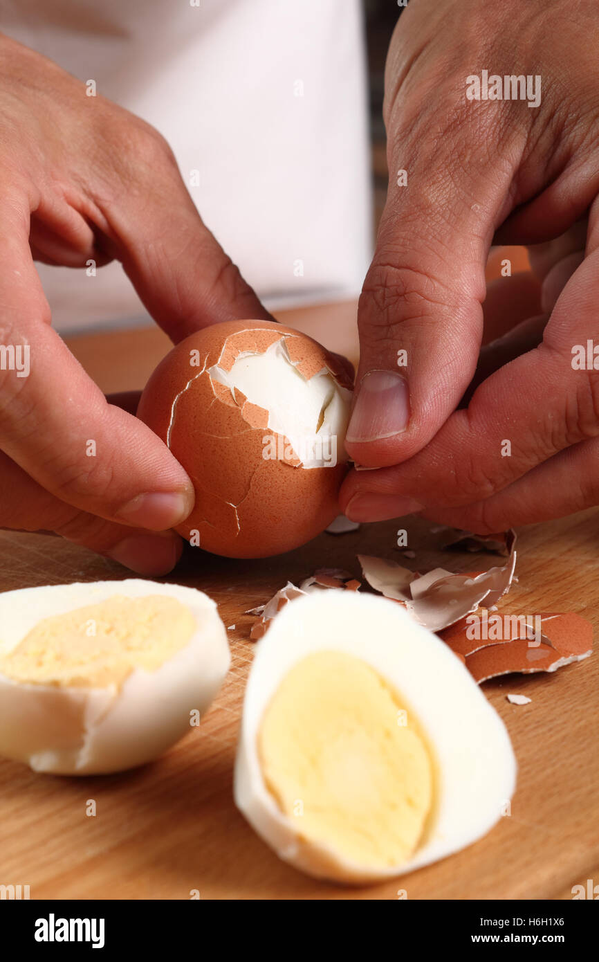 Peeling hard boiled eggs Stock Photo Alamy