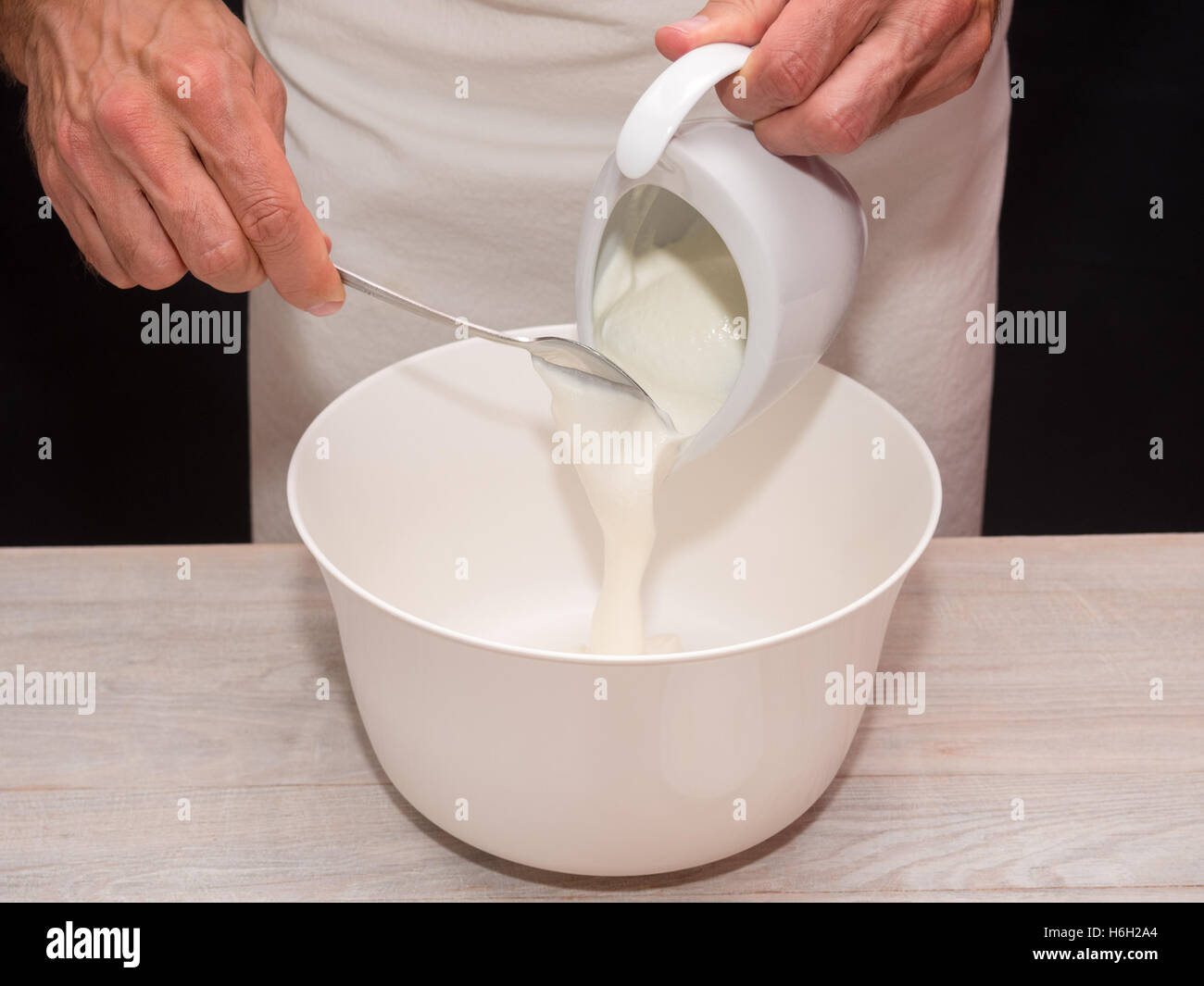 Adding Yogurt into bowl. Making Yogurt Cake. Stock Photo