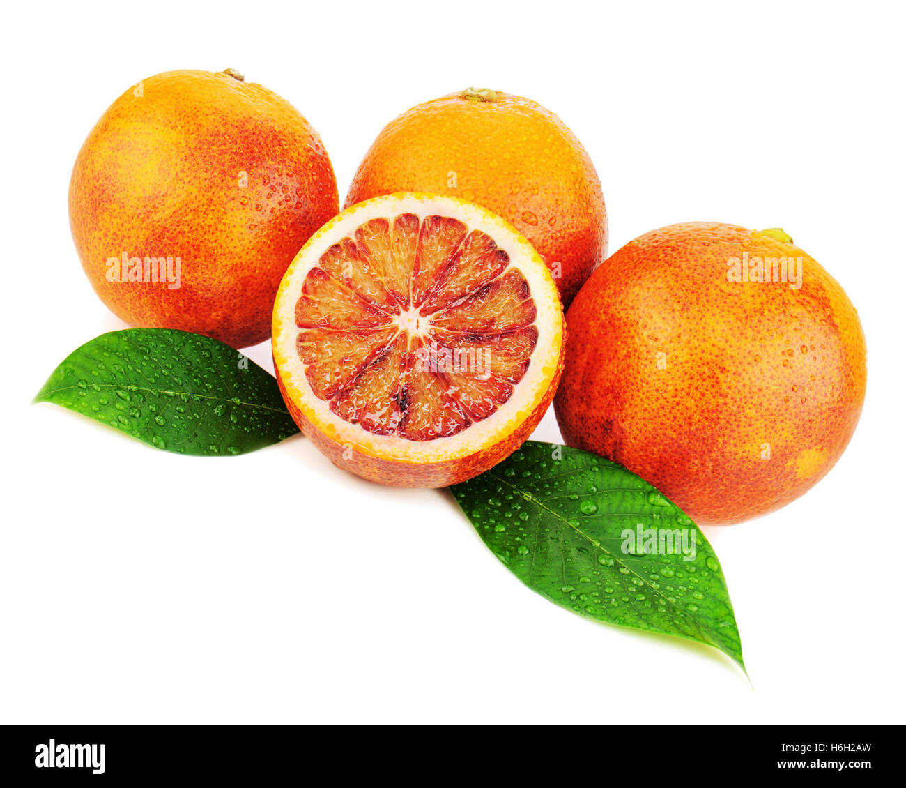 Ripe red blood oranges with cut and green leaves isolated on white background. Closeup. Stock Photo