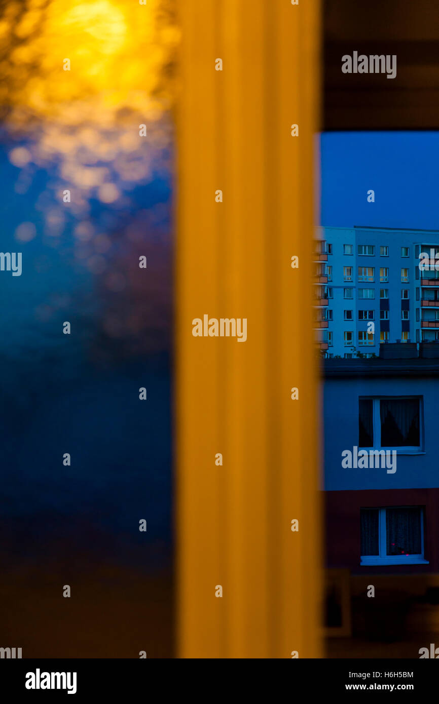 Tungsten lighting reflecting off a bumpy window, with another window in ...