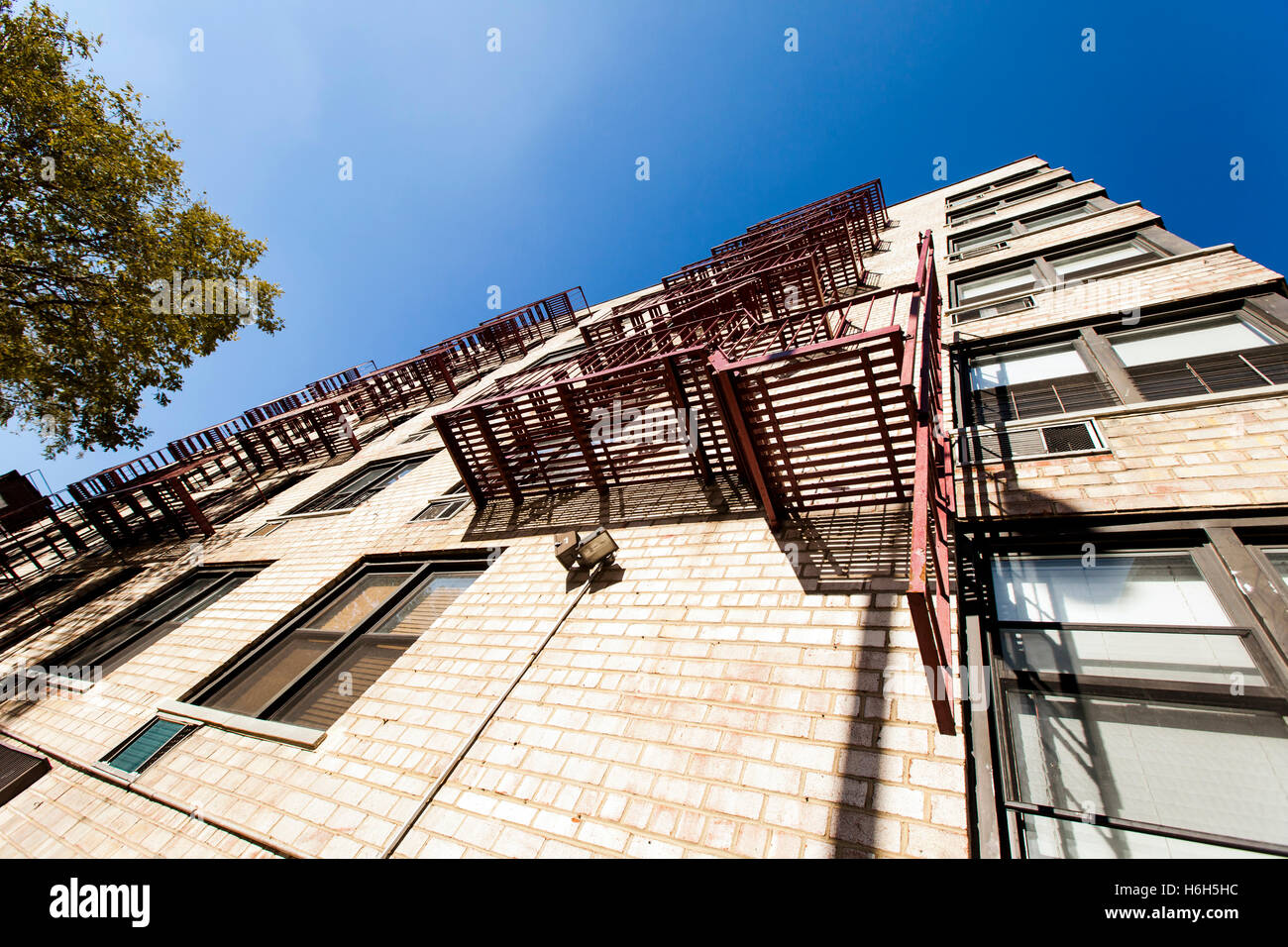 Low and wide angle view of a residential apartment building with the fire escape on the wall. Stock Photo