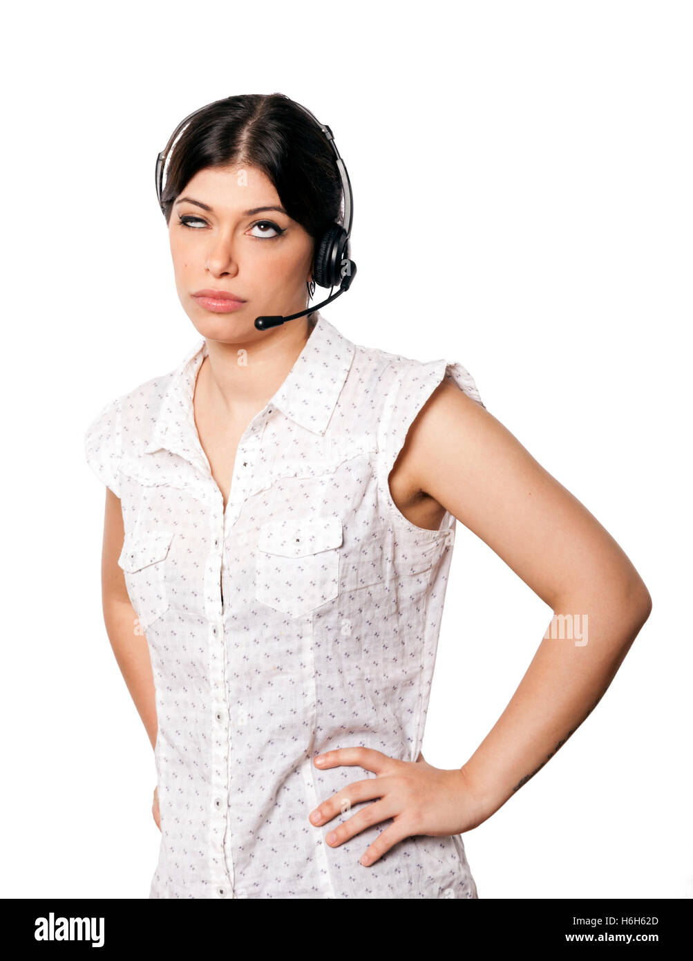 A bautiful young adult Caucasian woman wearing a headset and rolling her eyes up with a displeased expression. Isolated on white Stock Photo
