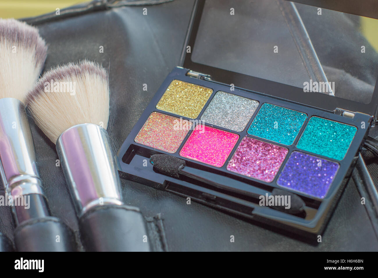 makeup brushes with a bright sparkle eyeshadow palette Stock Photo