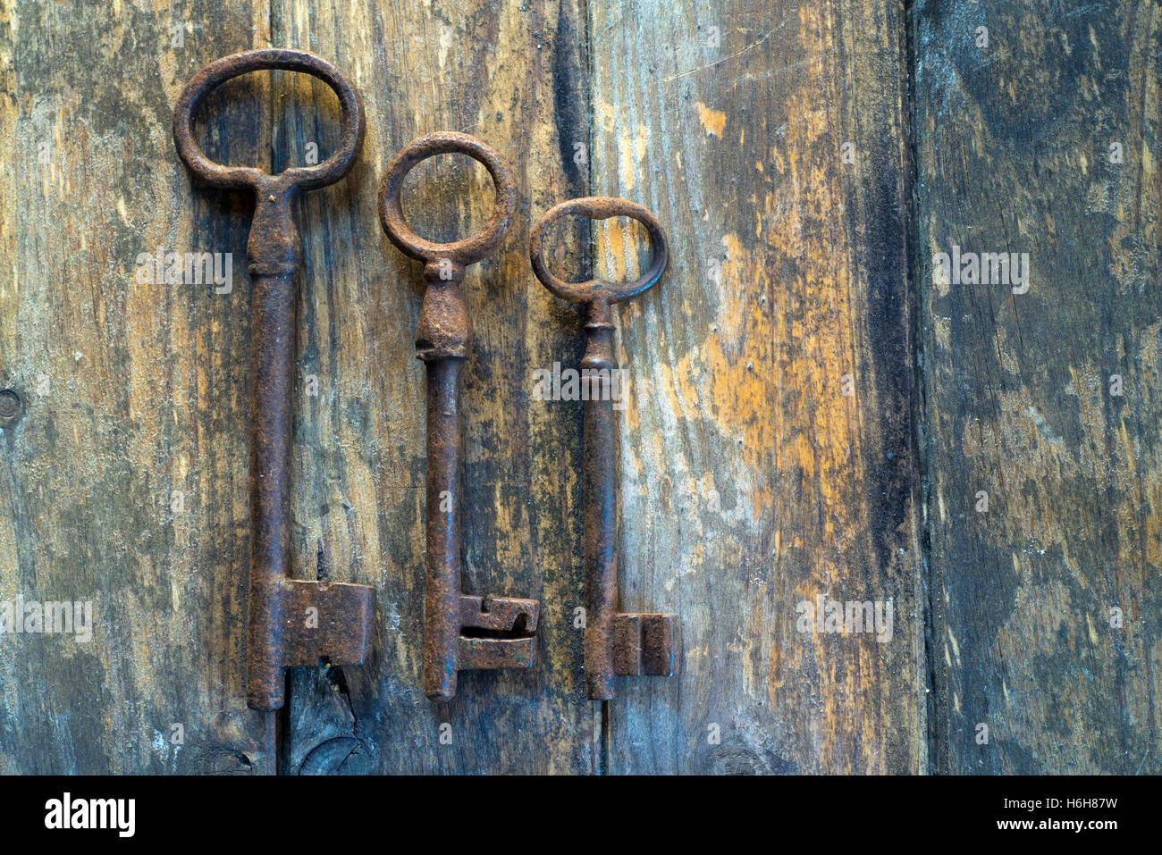 Three old keys on wooden table Stock Photo