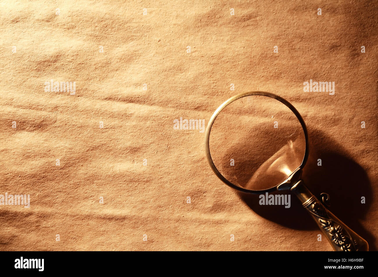 Vintage magnifying glass on nice old paper background Stock Photo