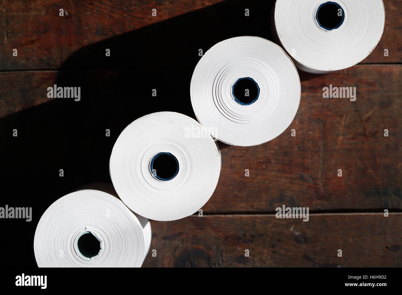 Set of white paper rolls in a row on dark background Stock Photo - Alamy