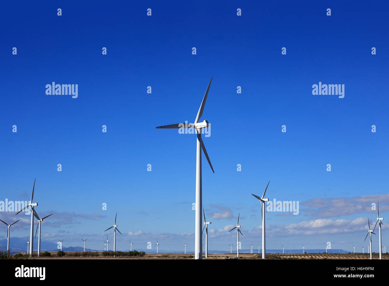 View of country landscape with wind turbines against blue sky Stock ...