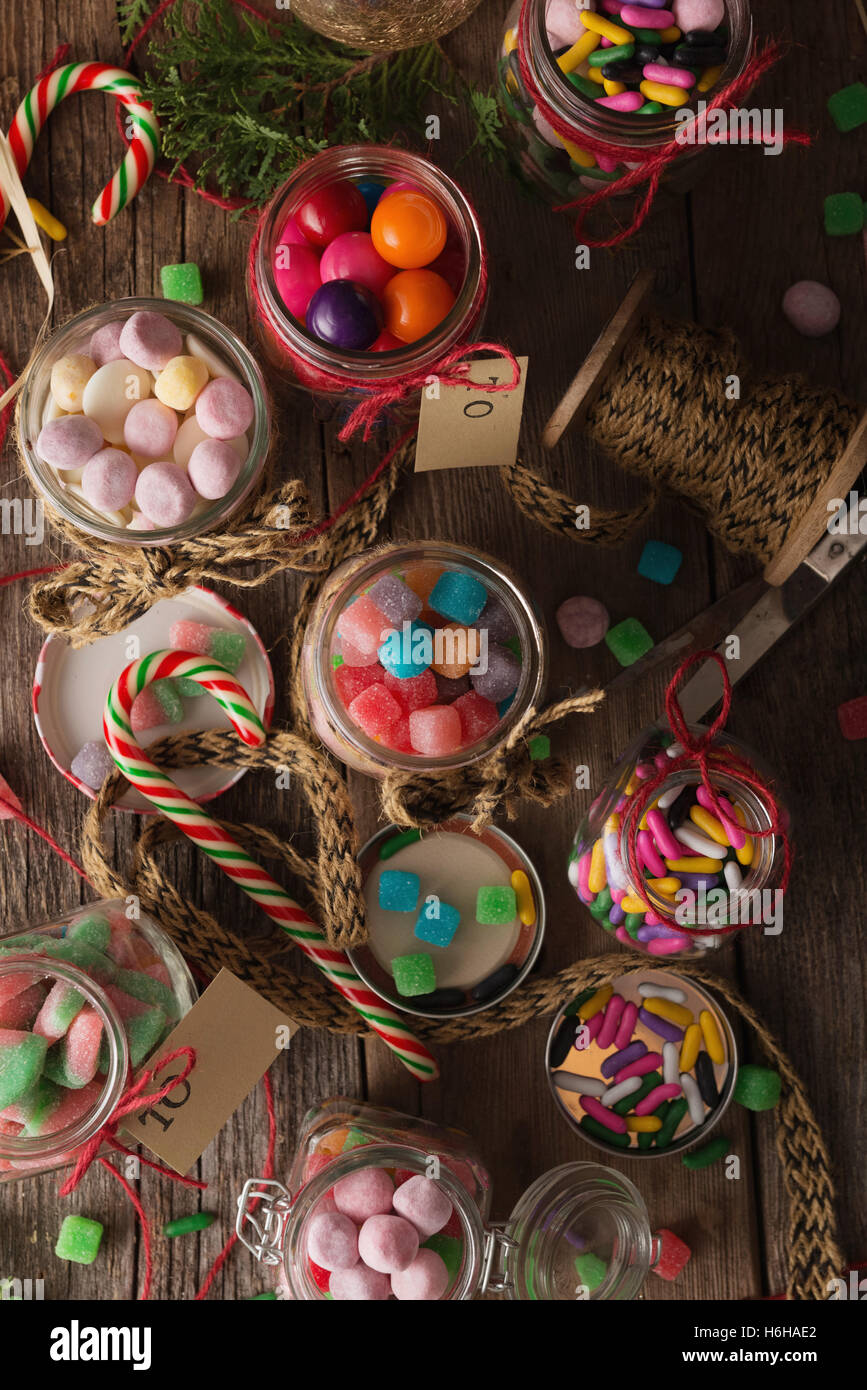 Various candies in jars for Christmas gifts on rustic wood table Stock Photo