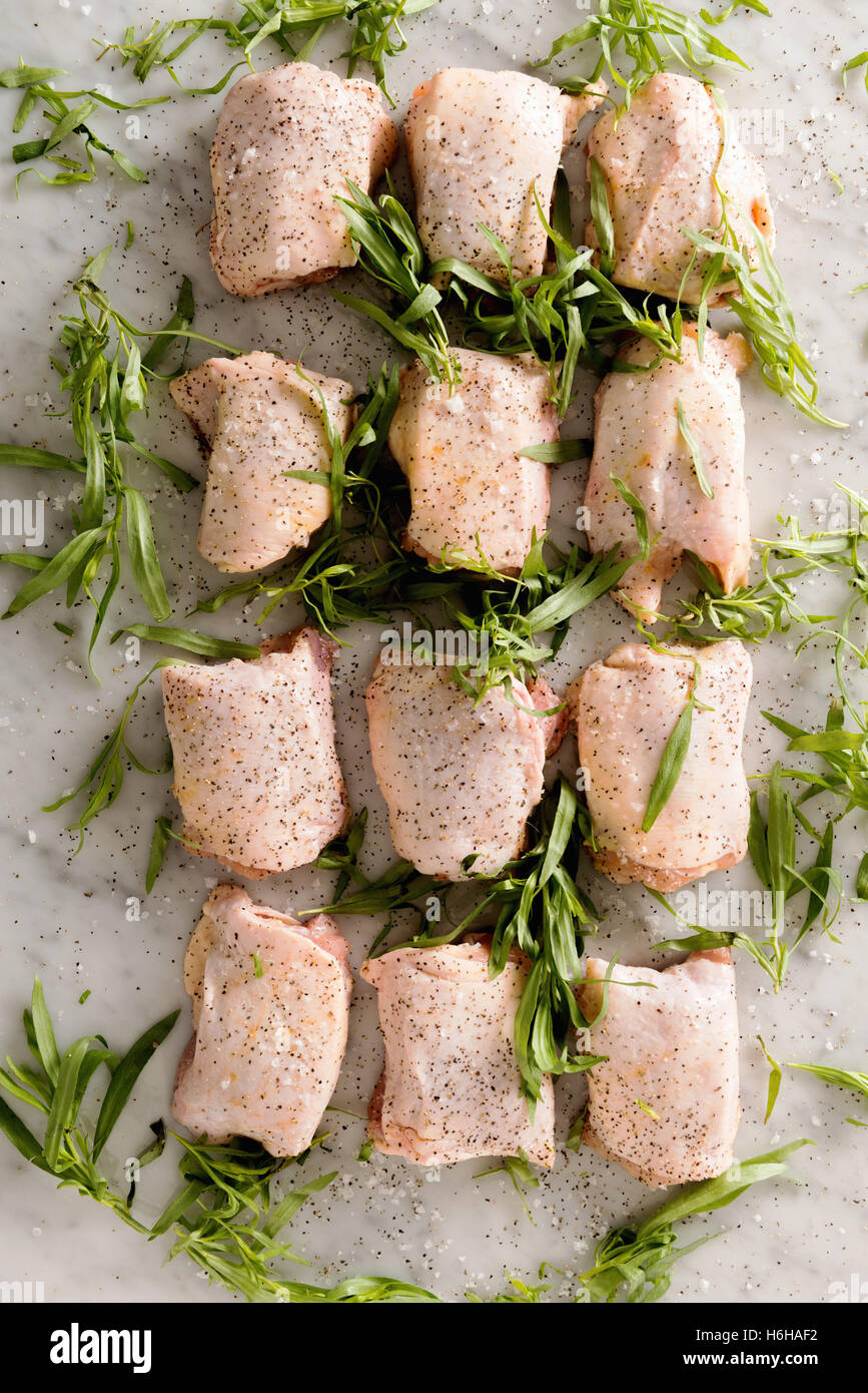 Raw chicken thighs with tarragon and spices ready to cook for dinner Stock Photo