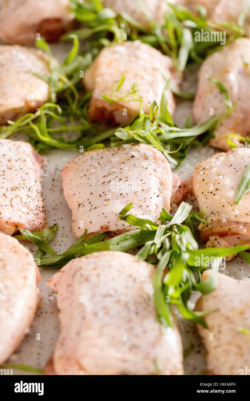 Raw chicken thighs with tarragon and spices ready to cook for dinner Stock Photo