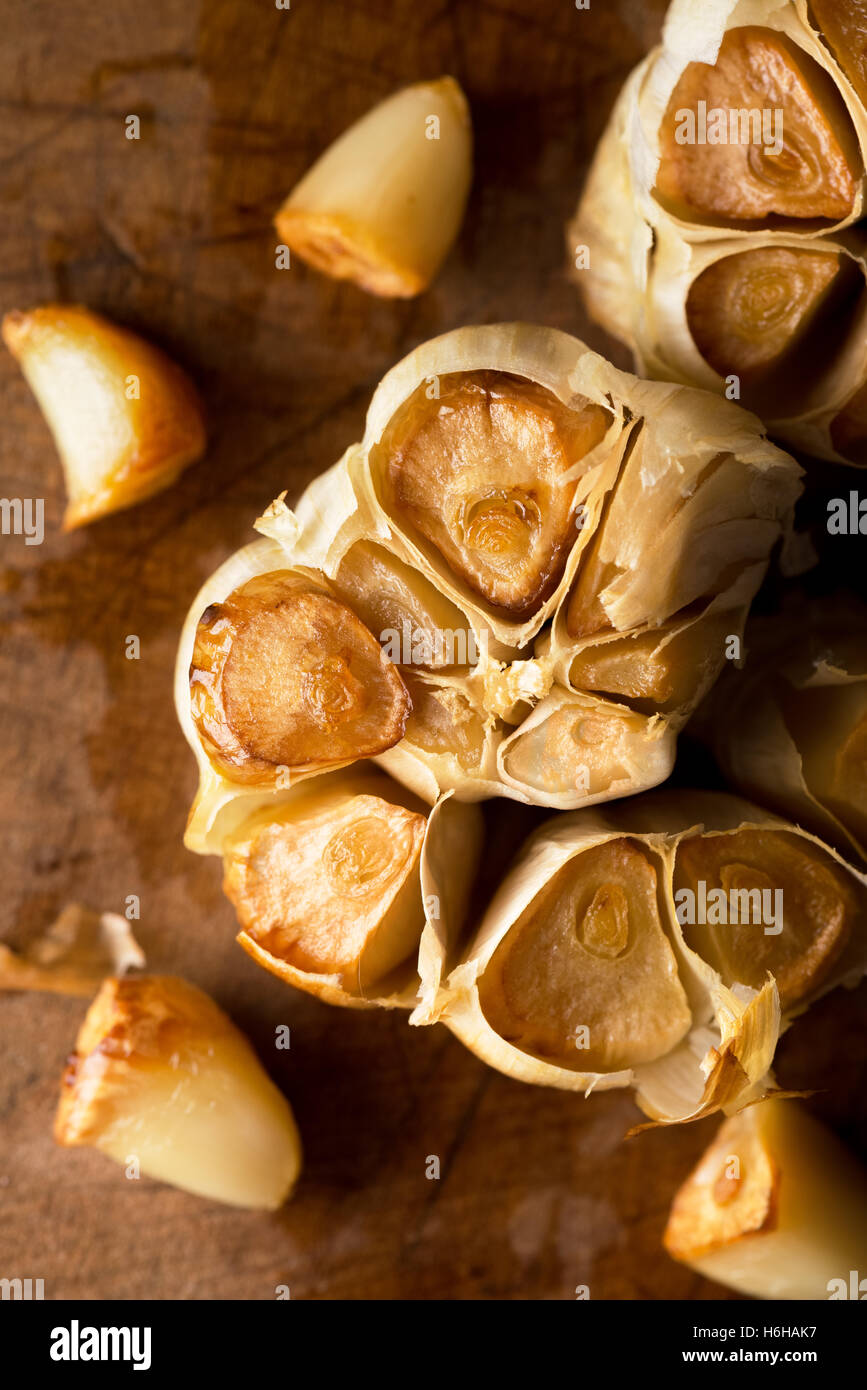 Roast whole garlic in rustic wood setting Stock Photo