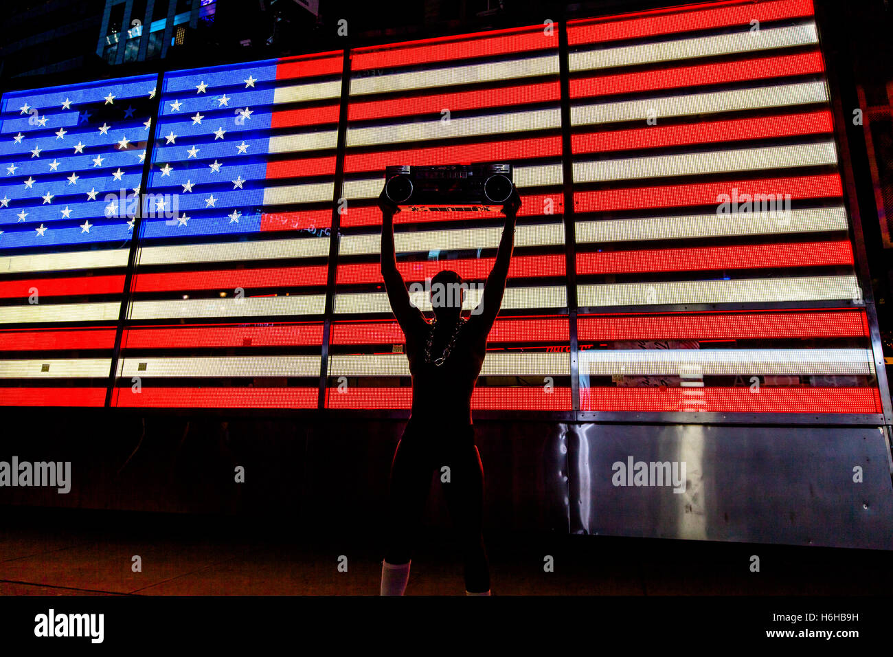 NEW YORK - NOV 11: Street performer in his underwear, holding a retro cassette player in front of the LED American flag in Times Stock Photo