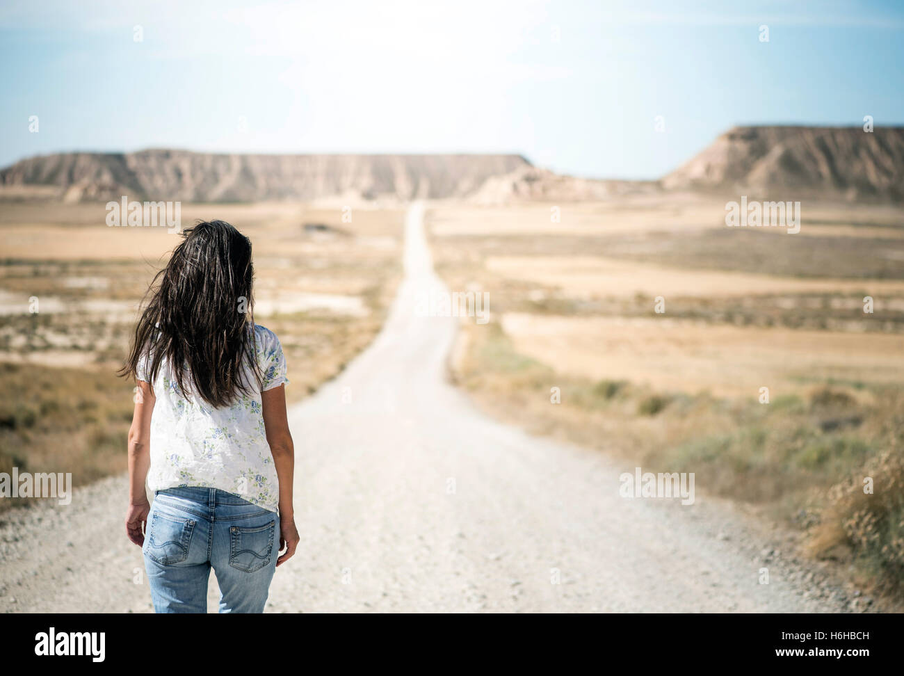 Woman walking on dirt road. Looking like a movie Stock Photo