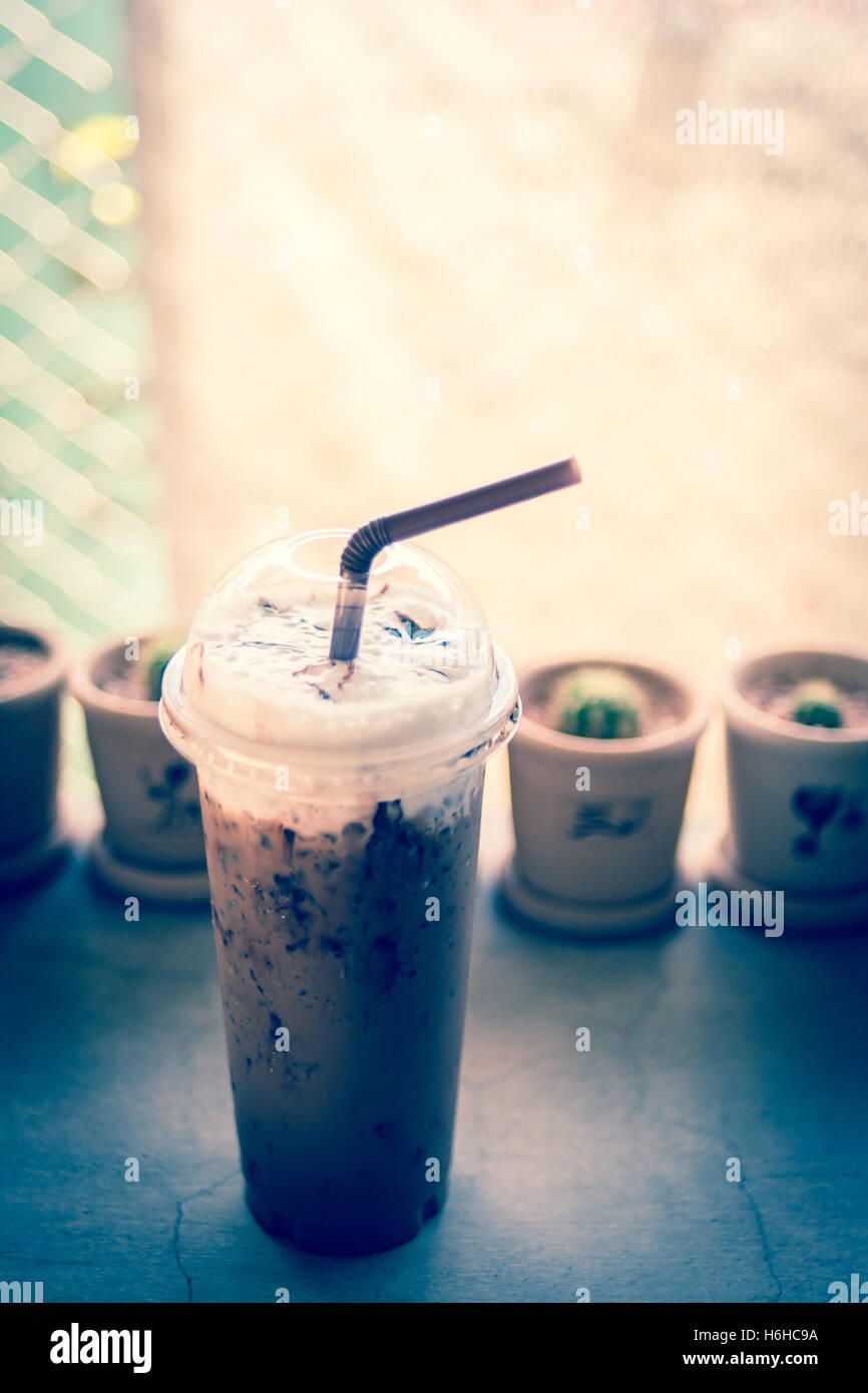 https://c8.alamy.com/comp/H6HC9A/iced-coffee-with-straw-in-plastic-cup-with-cuctus-backgroundvintage-H6HC9A.jpg