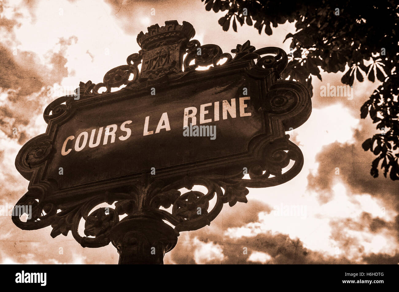 An ornate, sepia toned, vintage street sign in central Paris, France, with a grainy and distressed look. Stock Photo