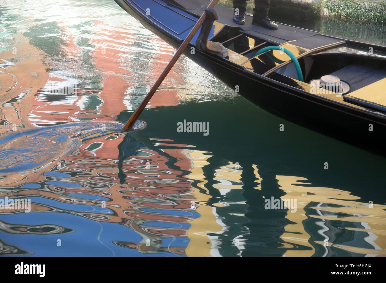Reflections of a gondola in the colourful water of a canal in Venice Italy Stock Photo