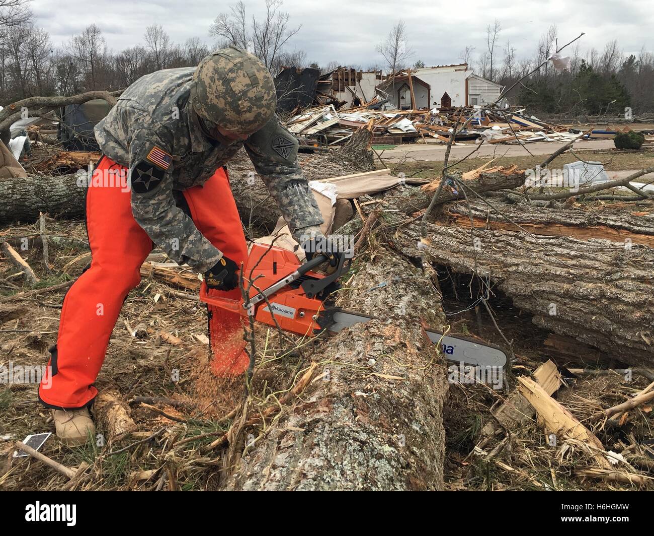 National Guard soldiers cut down fallen trees to and clear debris to open a blocked road after a severe storm and tornado February 25, 2016 in Essex County, Virginia. Stock Photo