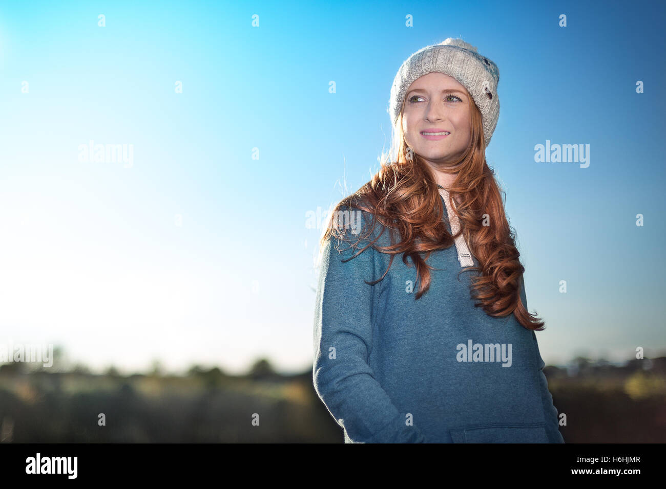 A redhead woman isolated against a blue sky Stock Photo